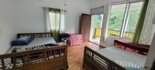 ein Schlafzimmer mit zwei Betten und einem Fenster in der Unterkunft Rongo Orange Valley Camp&Cottages in Jhalong