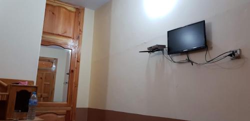 Un televisor de pantalla plana en la pared de una habitación. en Moon Rise Hotel, en Dargai