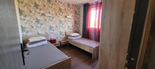 ein kleines Zimmer mit zwei Betten und einem Fenster in der Unterkunft Belle maison de vacances entre Saint-Malo et Mont-Saint-Michel. Le Clos Fleuri in Mont-Dol