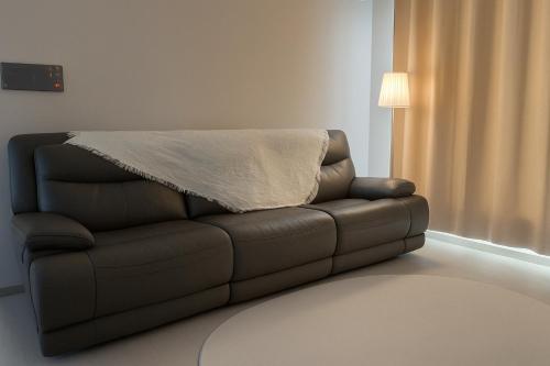 a brown couch with a blanket on top of it at Indeogwon stay 27 in Mabun-ni