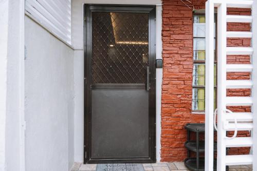 a black door on the side of a brick building at JZ Homestay - Cozy Home near SM Savemore, Caraga State University & BMC Hospital in Butuan
