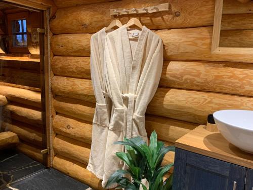 a robe hanging on a wall in a bathroom at Russet & Rowanberry - Rowanberry Retreat in Kriilevälja