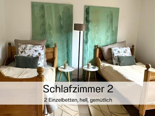 two beds in a room with green walls at EifelZeit 1 in Kall