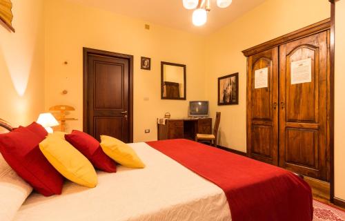 a bedroom with a large bed with red and yellow pillows at Su Connotu in Sestu