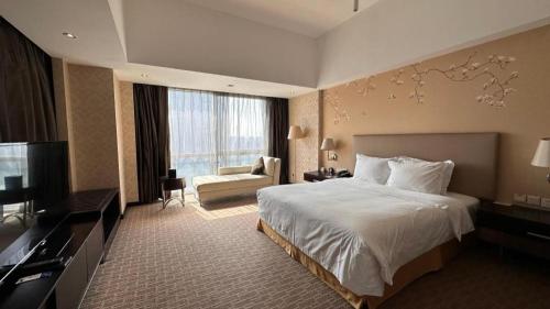 une chambre d'hôtel avec un lit et une télévision dans l'établissement Holiday Inn Xi'an Greenland Century City By IHG, à Xi'an