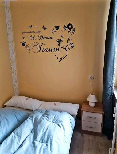 ein Schlafzimmer mit einem Bett und einer Wand mit einem Blumenrahmen in der Unterkunft Ferienwohnung Relax 5 in Hahnenklee-Bockswiese