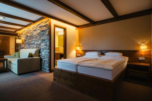 Un dormitorio con una cama grande y una silla. en Wellness hotel Horal, Velké Karlovice, en Velké Karlovice