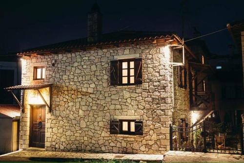 a stone building with lights on it at night at Guesthouse Armakas in Kalavrita