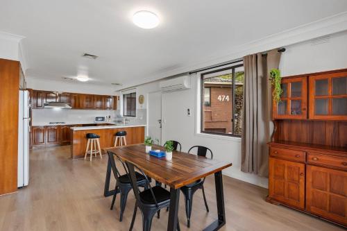 a kitchen and dining room with a wooden table and chairs at Econo Lodge Lilydale in Lilydale