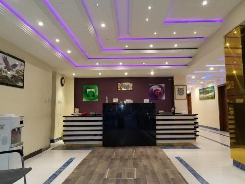un vestíbulo con luces moradas en el techo en Hotel Emerlad Crown, en Dargai