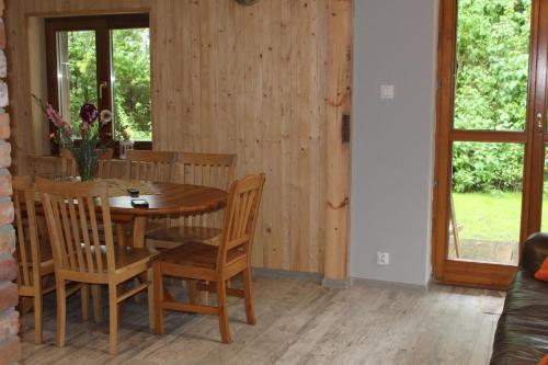 a dining room with a wooden table and chairs at Mazurska Chata Czepiela in Langendorf