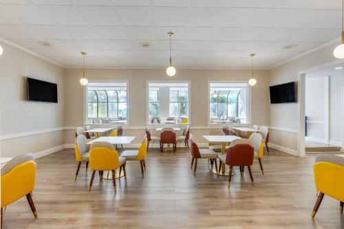 a dining room with tables and chairs and windows at The Lux Hotel & Conference Center, an Ascend Collection Hotel in Waterloo