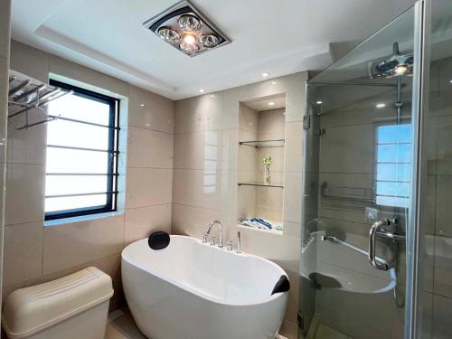 uma casa de banho com uma banheira, um chuveiro e um WC. em Shanghai Hongmin Inn em Xangai