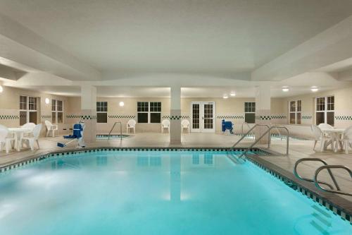 a pool in a hotel with chairs and tables at Country Inn & Suites by Radisson, Boise West - Meridian in Meridian