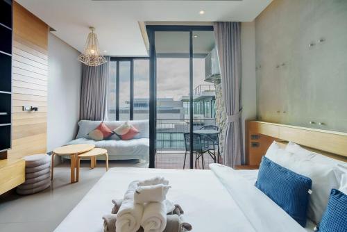 a bedroom with a bed and a living room with a couch at 405 Relife , 5 Minutes Walk To Nai Harn Beach in Rawai Beach