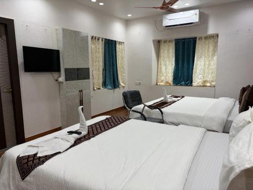 a hotel room with two beds and a flat screen tv at Hotel O Aditi Guest House in Salt Lake City