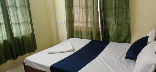 a bed in a room with green curtains at Hotel O Sharan Guest House in Calcutta Bara Bazar
