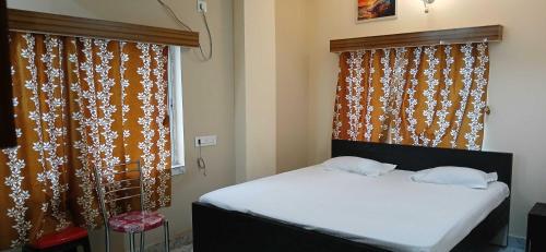 a bedroom with two beds and a window with curtains at Hotel O Sharan Guest House in Calcutta Bara Bazar