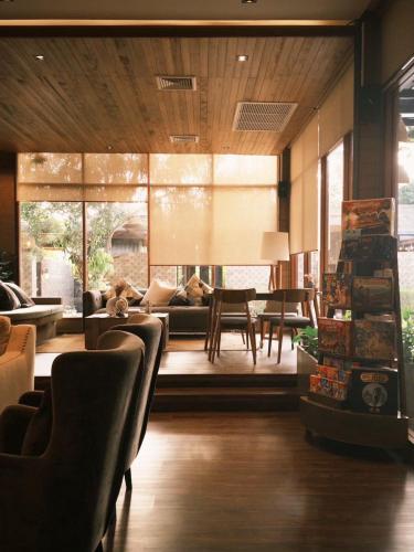 a living room with a couch and a table and chairs at The Memory Khaoyai in Pong Talong