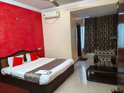 a bedroom with a bed and a red wall at Hotel O Laxmi Narsimha Temple Banjara Hills in Hyderabad