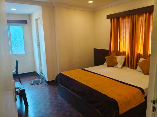 a bedroom with a bed with an orange curtain at Hotel O Laxmi Narsimha Temple Banjara Hills in Hyderabad