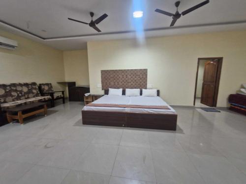 a large bedroom with a bed and a couch at - Hotel O Machilipatnam Railway Station Formerly Hasini Celebrations in Machilīpatnam