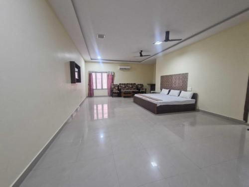 a bedroom with a bed and a living room at - Hotel O Machilipatnam Railway Station Formerly Hasini Celebrations in Machilīpatnam