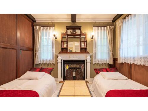 2 camas en una habitación con chimenea en FARM SIDE - Vacation STAY 24148v, en Tsumagoi