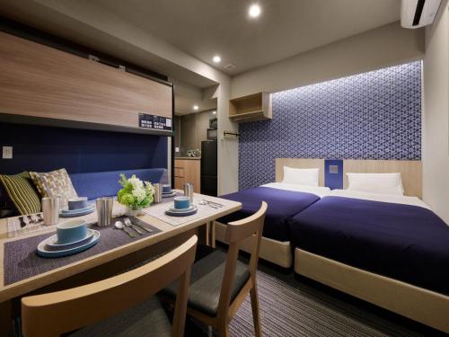 a hotel room with a bed and a dining table at Minn Nishi Kasai in Tokyo