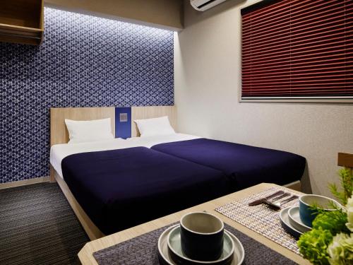 a bedroom with a bed and a table with plates on it at Minn Nishi Kasai in Tokyo