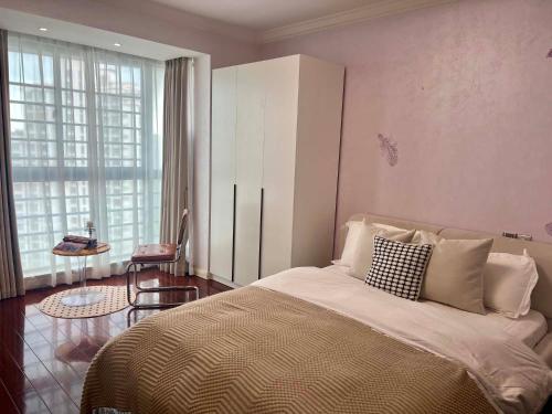 um quarto com uma cama, uma cadeira e uma janela em Shanghai Hongmin Inn em Xangai