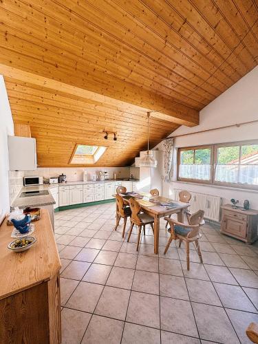 a kitchen with a wooden ceiling and a table and chairs at FeWo Honstein in Pfronten