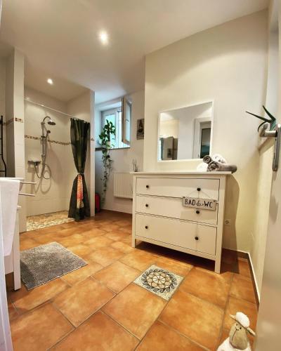 a bathroom with a white dresser and a mirror at Ferienwohnung Kotterer - Innenstadt Speyer in Speyer