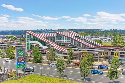 un gran edificio con una autopista delante de él en Five Bedrooms Near Schofields Station Direct Access to Sydney University & Parramatta, en Schofields