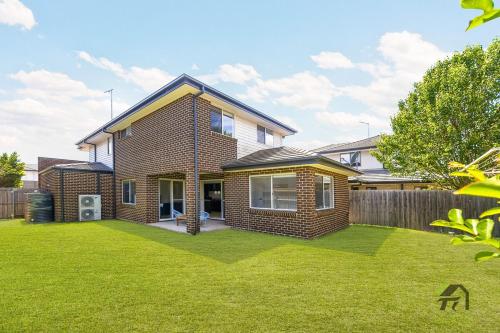 Una casa de ladrillo con césped delante. en Five Bedrooms Near Schofields Station Direct Access to Sydney University & Parramatta, en Schofields