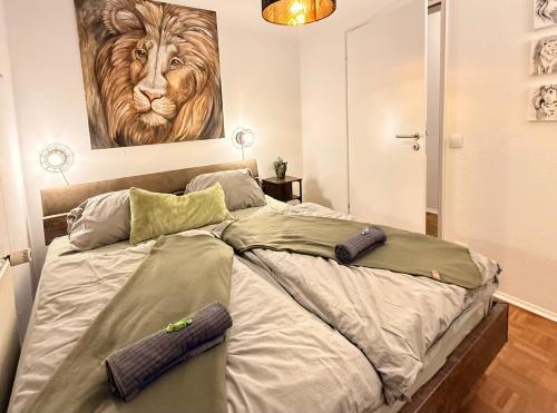 Schlafzimmer mit einem Bett mit Löwengemälde an der Wand in der Unterkunft Femo - Royal Siegen - Oberstadt - separater Eingang - zentral in Siegen