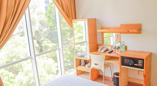 een slaapkamer met een bureau en een groot raam bij An Hotel Jakarta in Jakarta