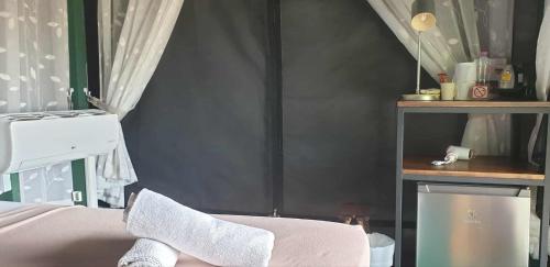 a bedroom with a bed with a towel on the seat at The Camping Field in Ban Kluai