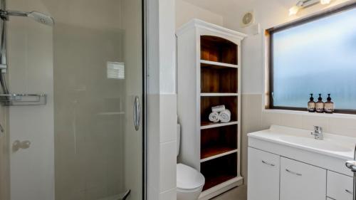 a bathroom with a shower and a toilet and a sink at Perfect on Perkins - Lake views in Frankton Wharf