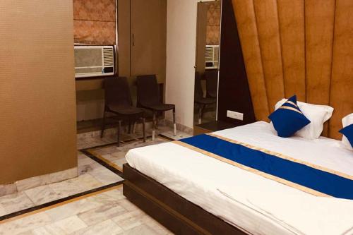 a room with two beds and chairs and a table at Hotel The Novelty in Kānpur