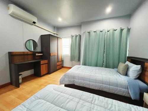 Un dormitorio con dos camas y un espejo. en BirdHostel Chiangrai, en Chiang Rai
