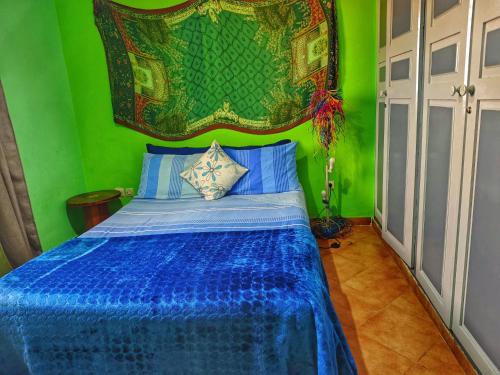a bedroom with a blue bed with a green wall at Ocean Hideaway - Sea View in Essaouira