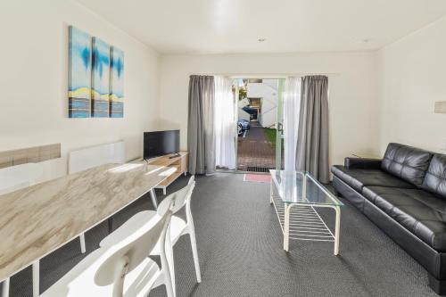 a living room with a table and a couch at Birchwood Spa Motel in Rotorua