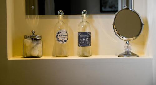 a bathroom shelf with two bottles and a mirror at Suardal Guest House in Fort Augustus