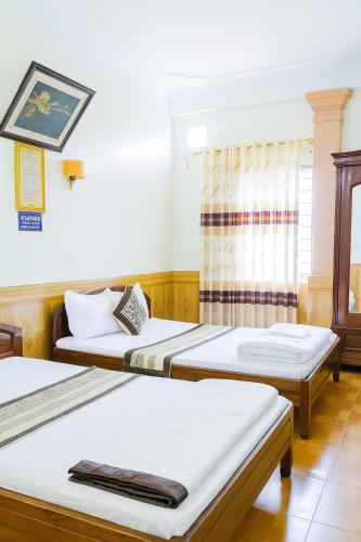 a room with two beds and a window at Phương Phương 1 Hotel in Hà Tĩnh