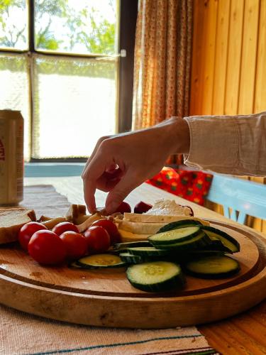 una persona sta tagliando le verdure su un tagliere di Breb s Cosy Barn a Breb