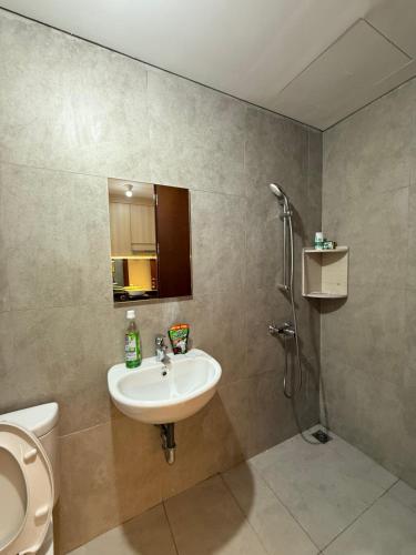 a bathroom with a sink and a toilet at Pollux Habibie Deluxe 3 City View lt 28 by Superstay in Batam Center