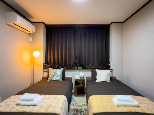a room with two beds and a curtain at MANDO Hotel 101 in Tokyo