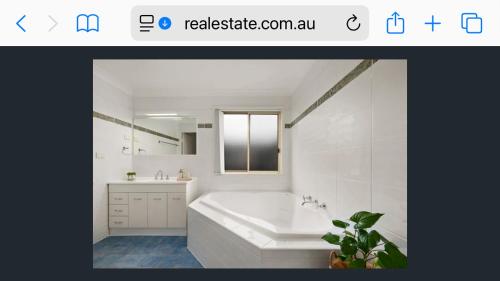 スワンジーにあるSwansea Lake Front Retreat with private jettyの浴槽と洗面台のある白いバスルーム