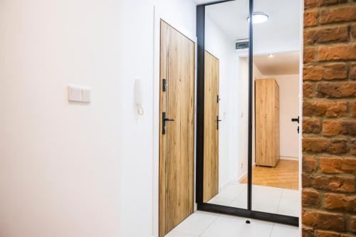 een badkamer met een spiegel naast een bakstenen muur bij Clara in Rzeszów